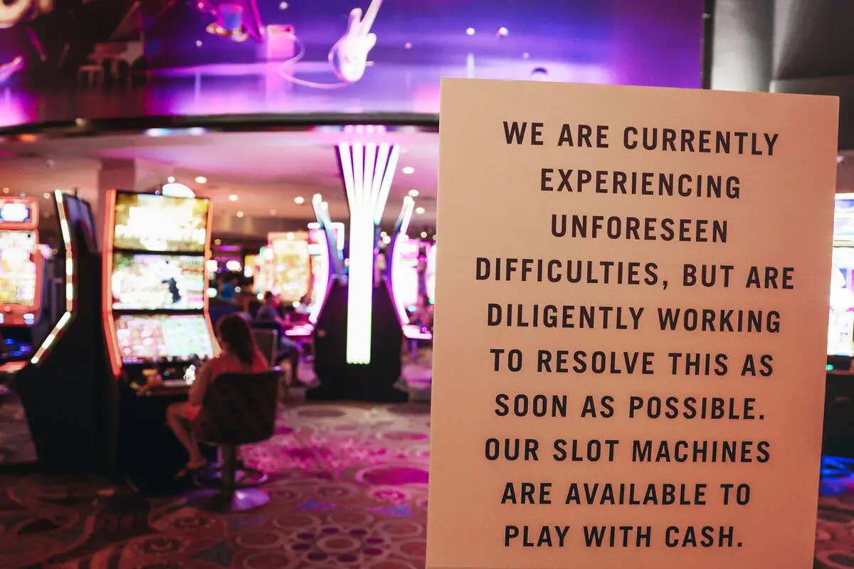 A photograph taken at the entrance of an MGM casino during the hack. In the front is a sign which reads, "We are currently experiencing unforeseen difficulties, but are diligently working to resolve this as soon as possible. Our slot machines are available to play with cash."